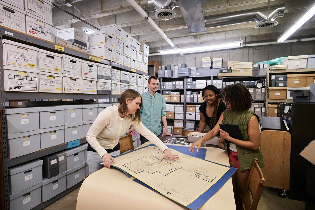 Students and faculty examine historic documents and blueprints at Ursuline College