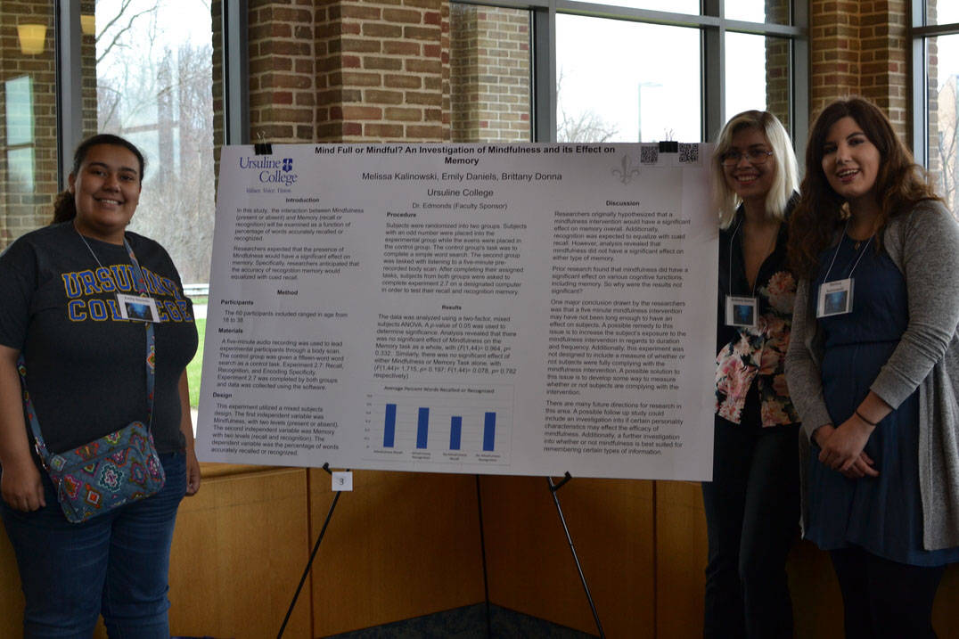 Student pose with poster at Student Research Symposium