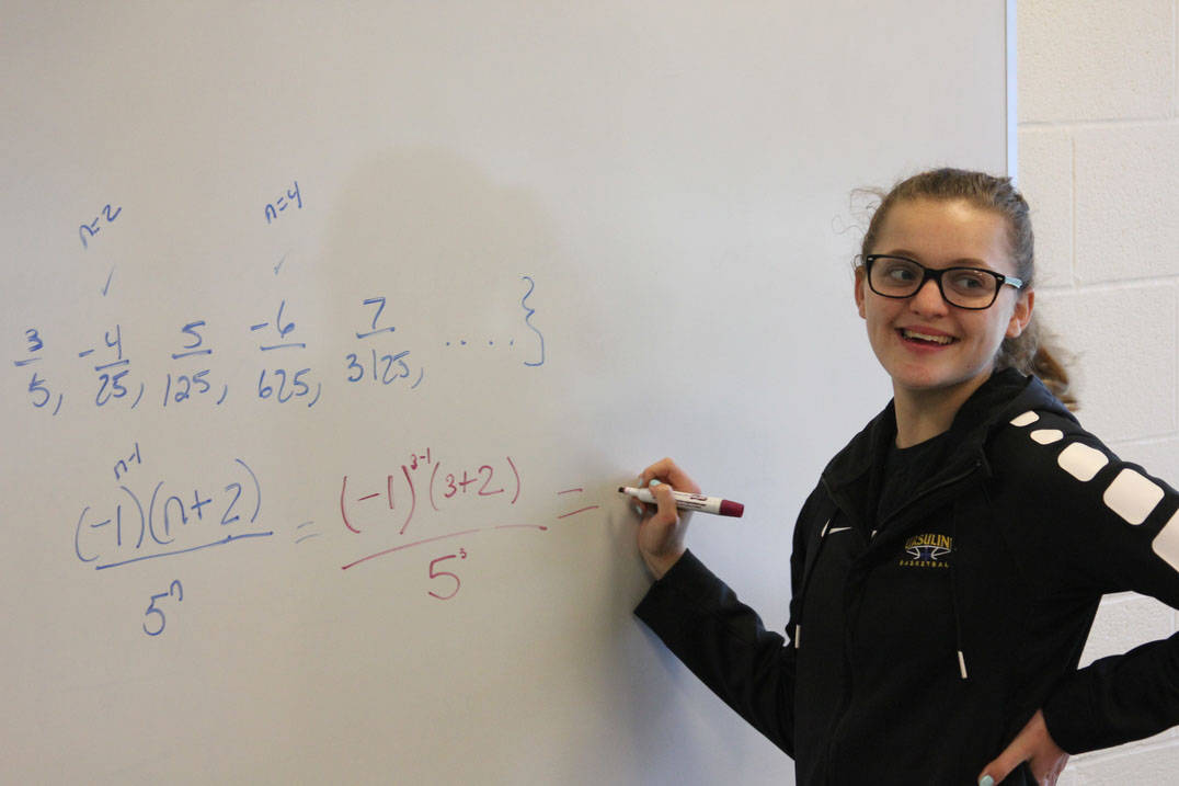 Ursuline math student completes equation at the board