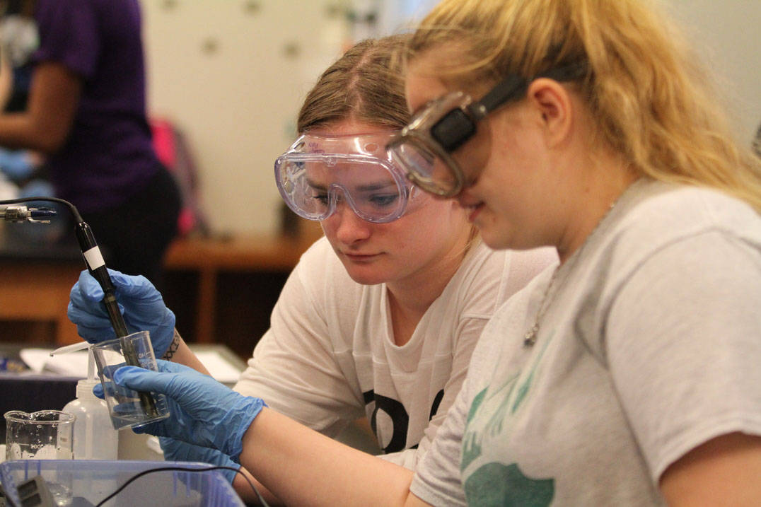 Two chemistry students conduct experiment