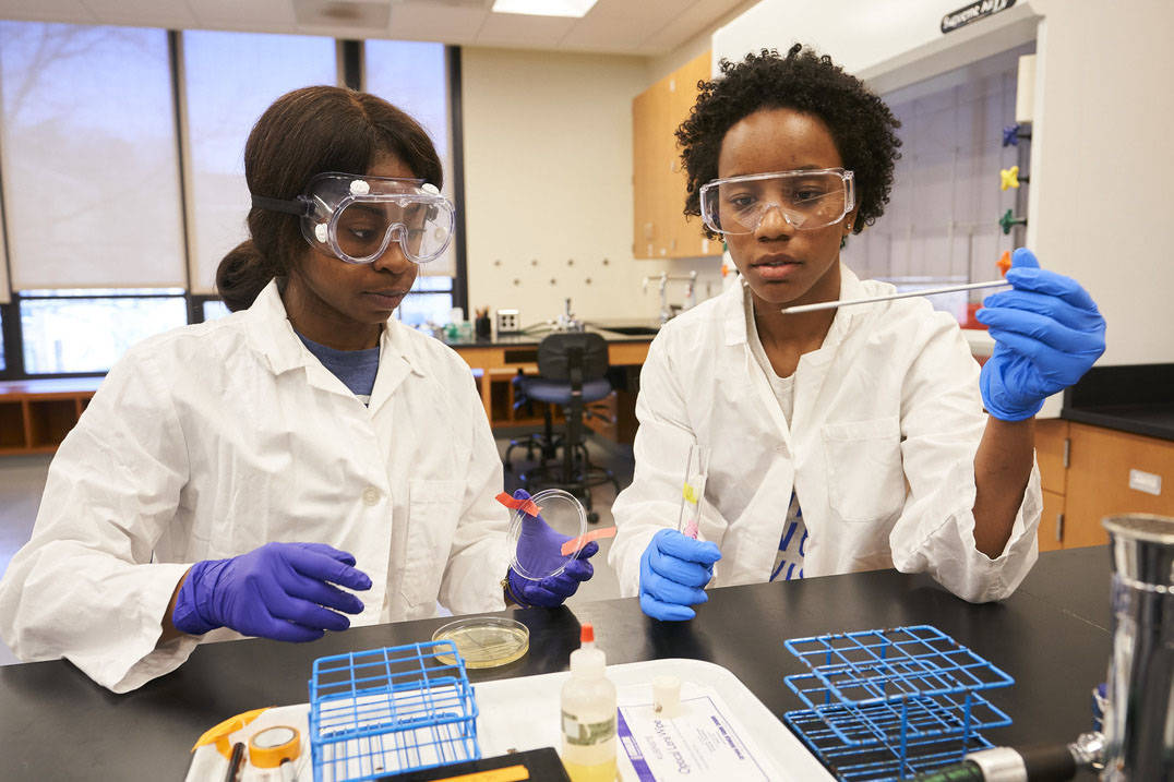 Two students work with petri dish