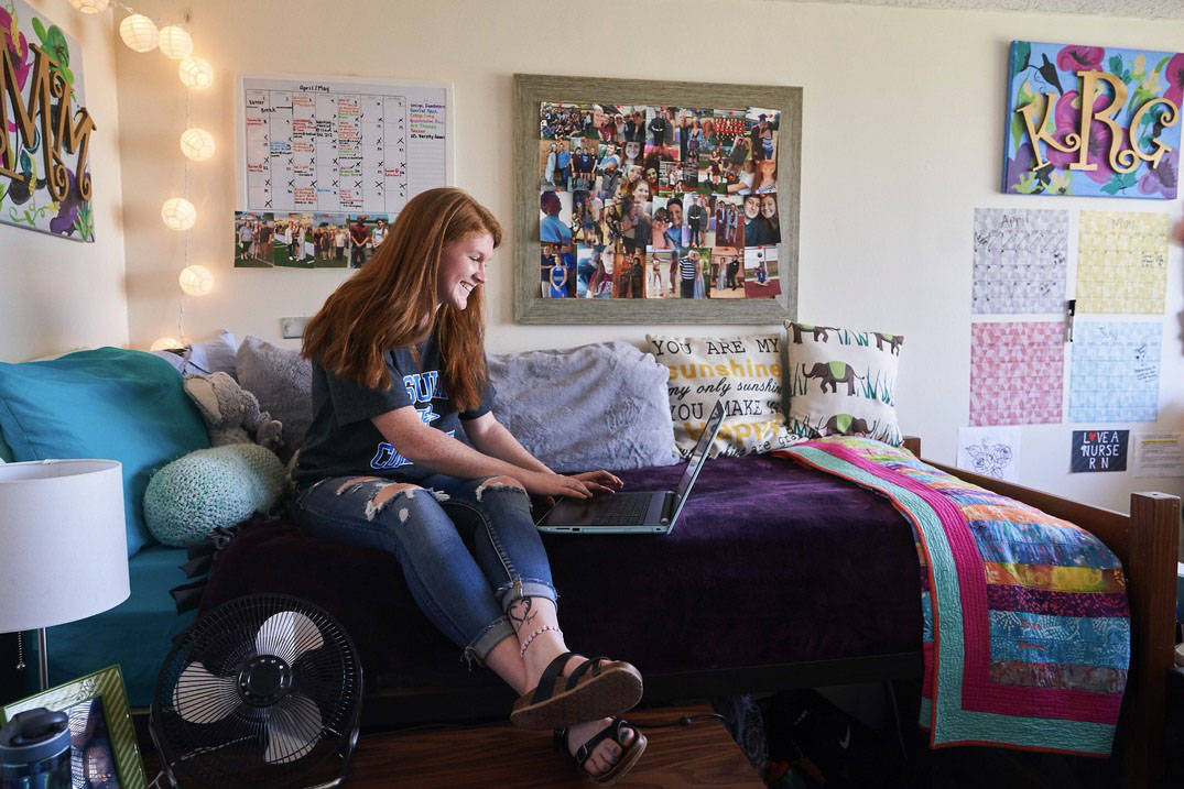 A student studying in her room in a residence hall at Ursuline College